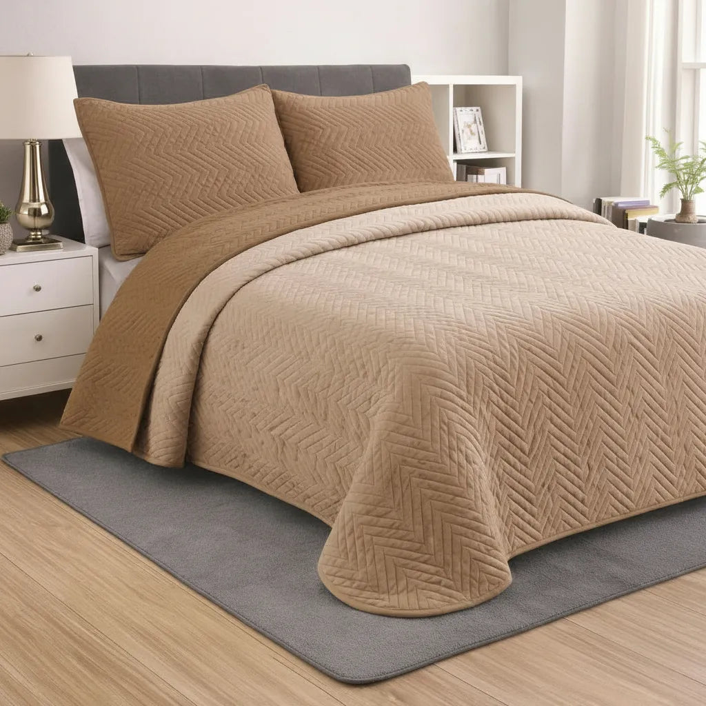 Beige quilt and pillows on a bed in a bedroom setting