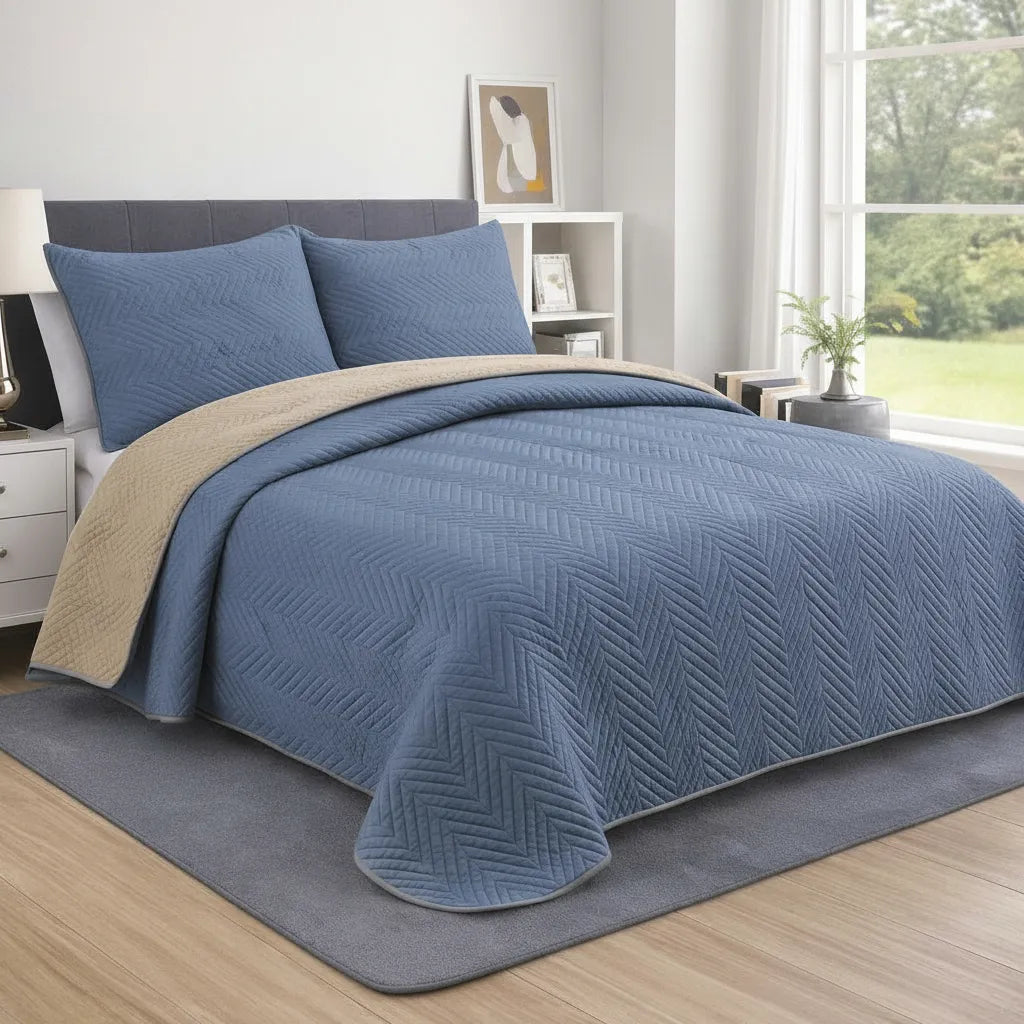 Blue quilt with beige border on a bed in a bedroom setting