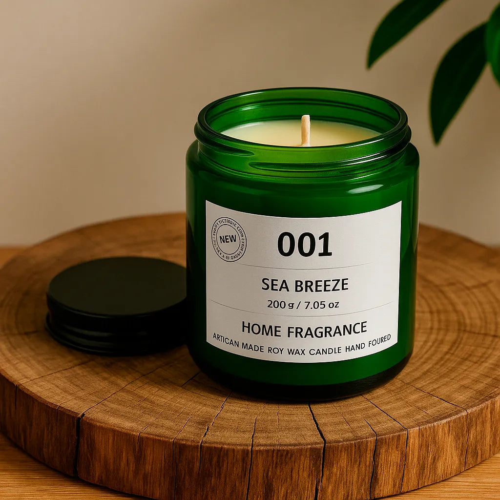 Green candle in a jar labeled '001 Sea Breeze' on a wooden surface.